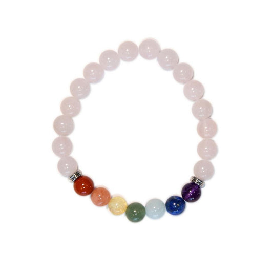 Vue de dessus d'un bracelet élastique circulaire composé principalement de perles de quartz rose pâles, avec une section de sept perles de pierres naturelles colorées représentant les chakras et des séparateurs métalliques, sur un fond blanc propre.