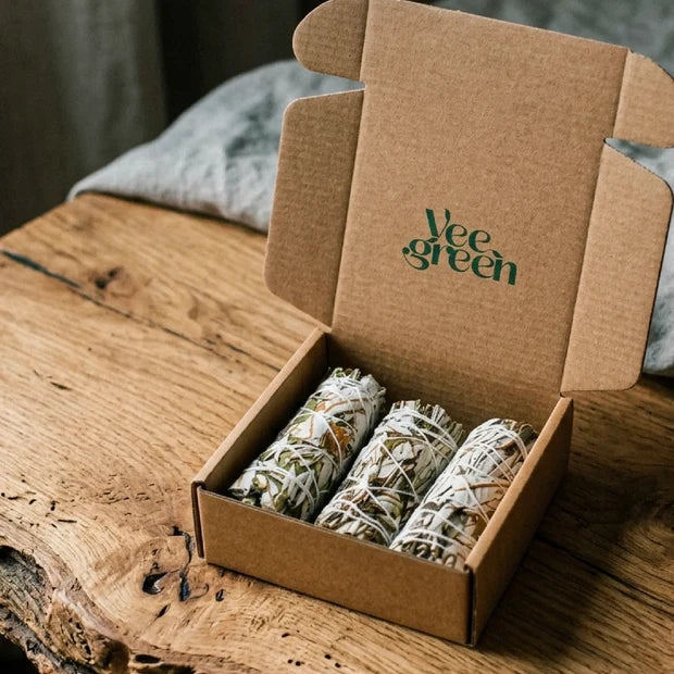 Coffret en carton ouvert contenant 3 bâtons de fumigation de Yerba Santa posé sur une table en bois naturel - Myvelyshop