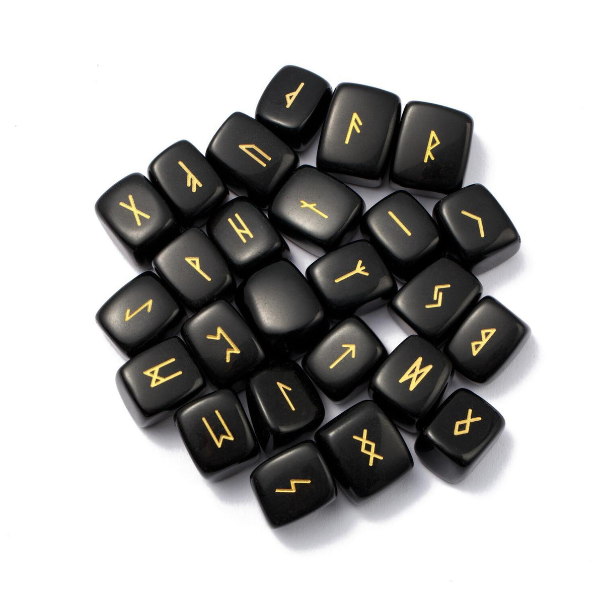 Ensemble de 25 runes divinatoires en obsidienne noire polie avec gravures dorées des symboles Futhark, regroupées au centre sur un fond blanc pur.